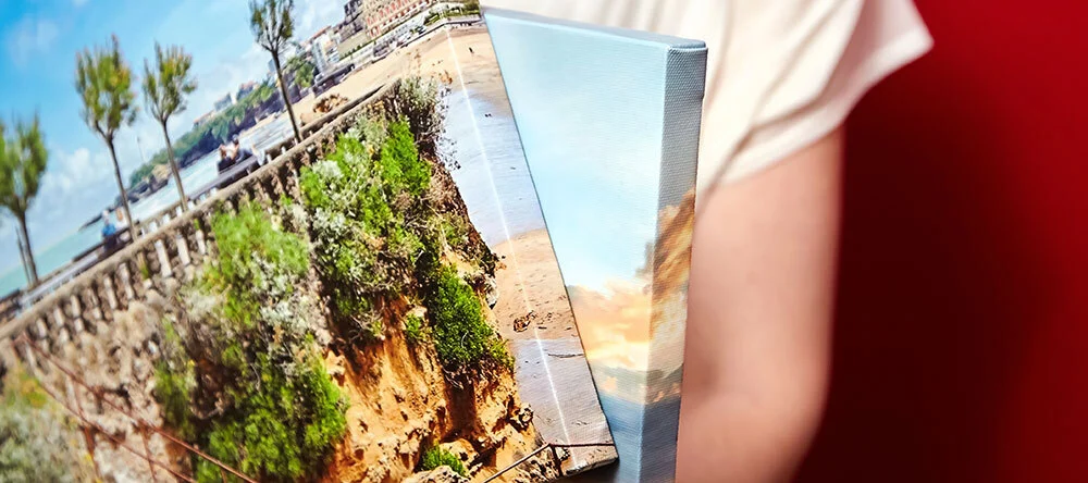 Is Canvas Waterproof? Person carrying two framed canvas prints.