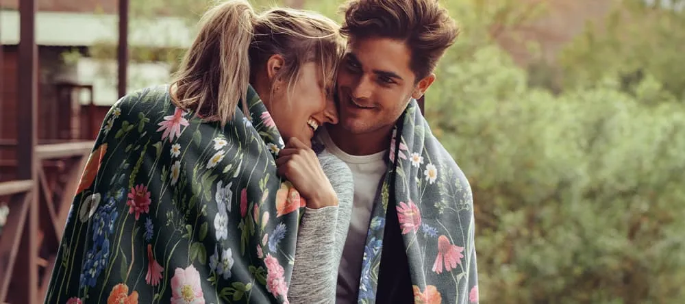couple snuggling in a throw blanket