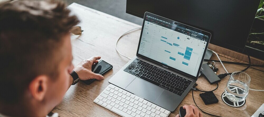Where to Buy Canvas Prints in the US. Man looking at spreadsheet on laptop.