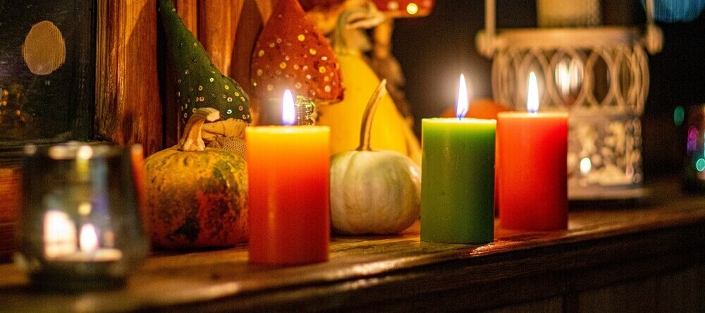 How to Make Personalized Halloween Gifts. Multicolored candles next to pumpkins.
