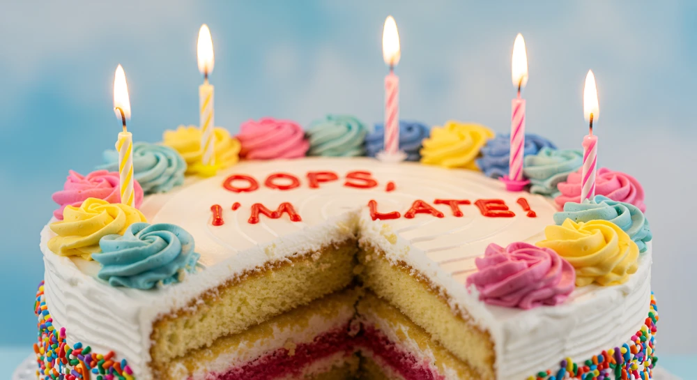 Woman laughing at a funny belated birthday card, showing humor in late wishes