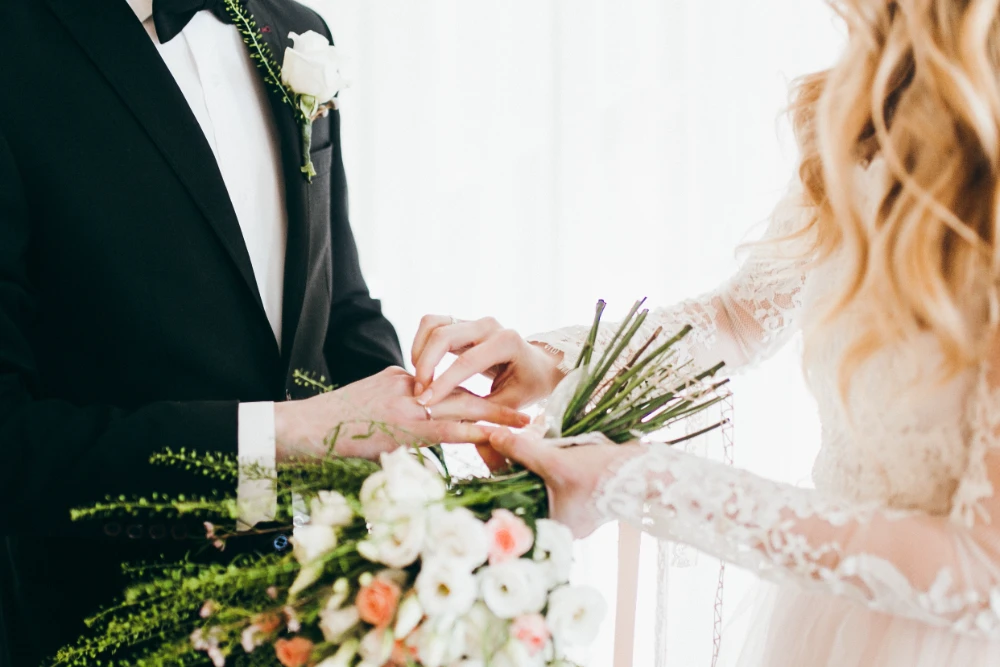 A couple holding hands during a wedding ceremony, signifying religious and spiritual wedding blessings