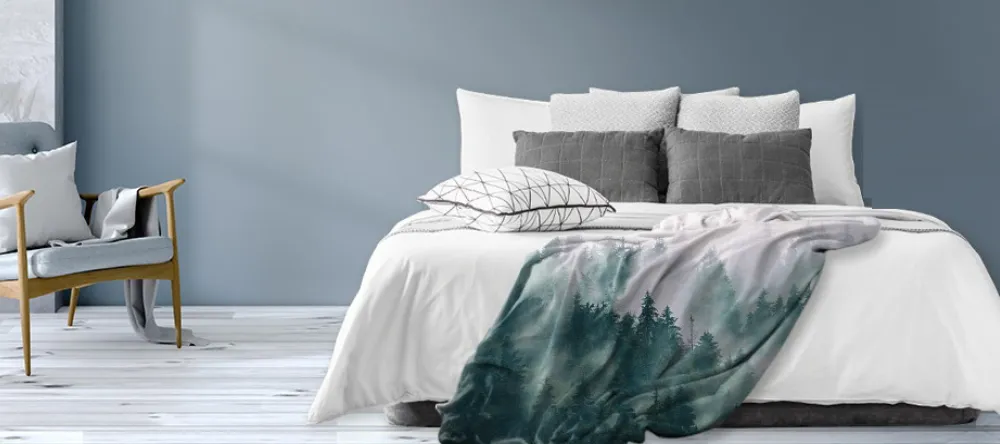 Where to create a blanket with your own picture on it. Personalized blanket with forest photo on bed.