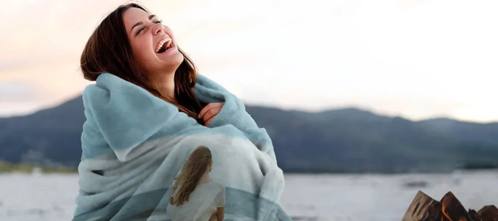 Where to create a blanket with your own picture on it. Woman covering herself in personalized blanket.
