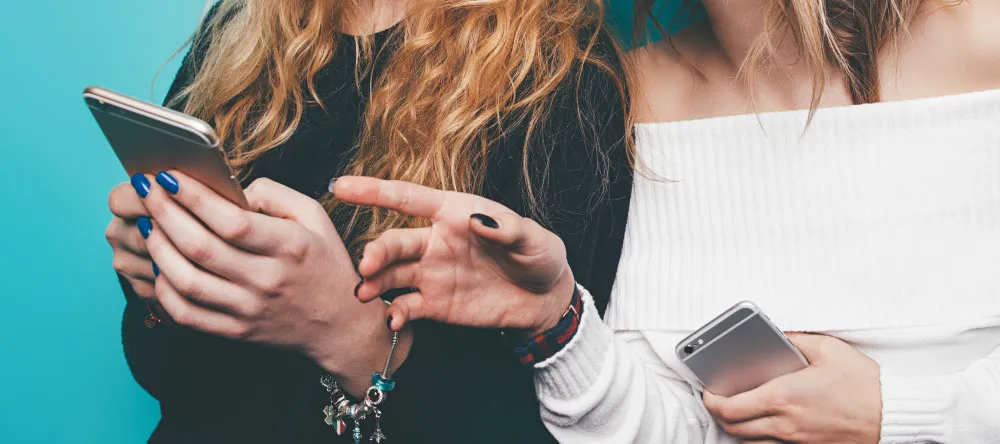 Why Should I Buy Canvas Prints. Two women with phones.