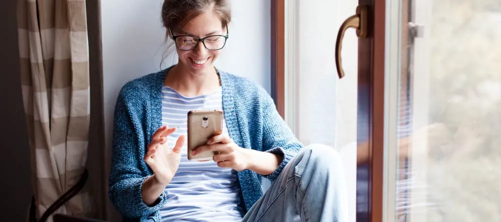 Printing Phone Photos on Canvas. Young woman online shopping on her phone.