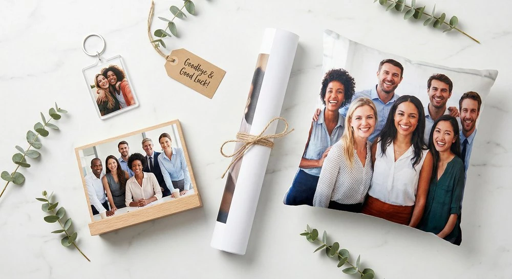 Budget-friendly personalized going away gifts including photo keychain, desktop plaque, poster print, and photo pillow arranged in a styled flat-lay
