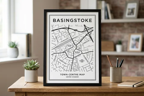 basingstoke city map poster – a framed minimalist black-and-white street map poster of the town centre on a desk