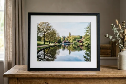 framed photo print basingstoke – a framed print of Eastrop Park lake with a white mount and black frame standing on a console table