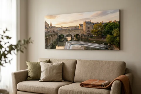 panoramic canvas print bath – a wide panoramic canvas of the Avon at Pulteney Weir at sunset hung above a long sofa