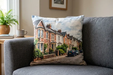 photo cushion exeter – a plush square cushion printed borderless with a St Leonard's terrace on a grey sofa