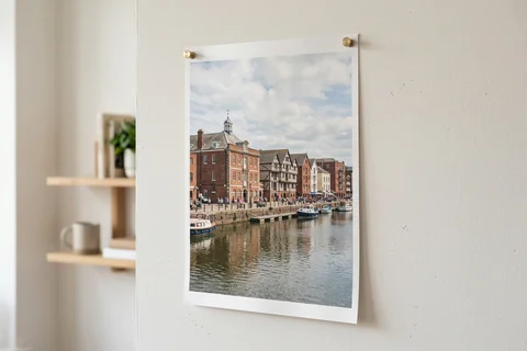 poster print exeter – an unframed poster print of the Quay's warehouses pinned to a pale wall