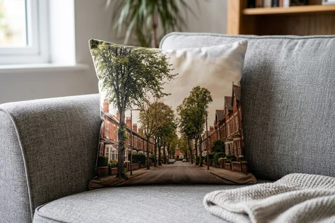 photo cushion hull – a plush square cushion printed borderless with an Avenues terrace on a grey sofa