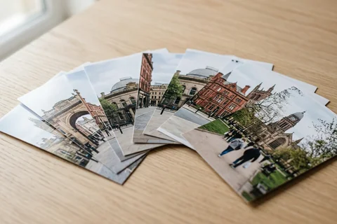 photo prints leeds – a loose fan of 10×15 cm photo prints of Leeds street scenes on a pale wooden table