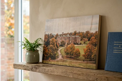 photo print on wood leeds – a wood print of Temple Newsam in autumn with the grain visible through the image, leaning on a shelf