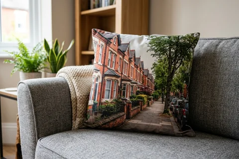 photo cushion leicester – a plush square cushion printed borderless with a Clarendon Park terrace on a grey sofa