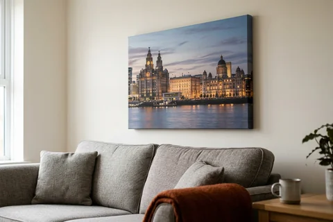 canvas print liverpool – a gallery-wrapped canvas print of the Three Graces at dusk hung above a sofa