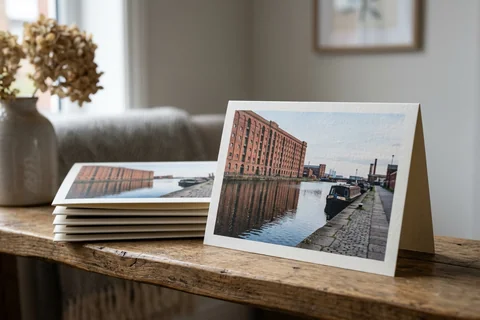 photo cards liverpool – a stack of folded greetings cards with a photograph of the Leeds and Liverpool Canal at Stanley Dock on the front, one propped open