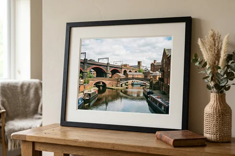 framed photo print manchester – a framed print of Castlefield's canal basin with a white mount and black frame standing on a console table