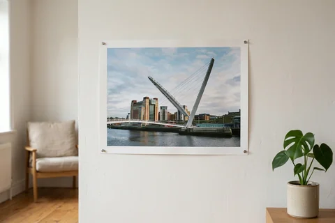 poster print newcastle – an unframed poster print of the Millennium Bridge tilting pinned to a pale wall