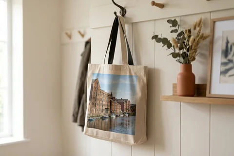 photo tote bag newcastle – a cloth tote bag printed with a photograph of Ouseburn's warehouses hanging on a hallway hook