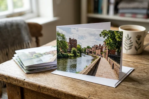 photo cards norwich – a stack of folded greetings cards with a photograph of the Wensum riverside walk on the front, one propped open