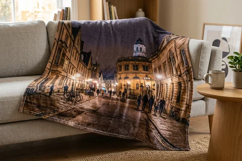 photo blanket oxford – a plush blanket printed edge to edge with Broad Street at night draped over a sofa
