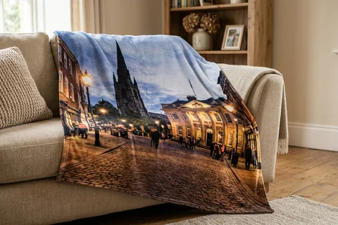 photo blanket york – a plush blanket printed edge to edge with St Helen's Square at night draped over a sofa