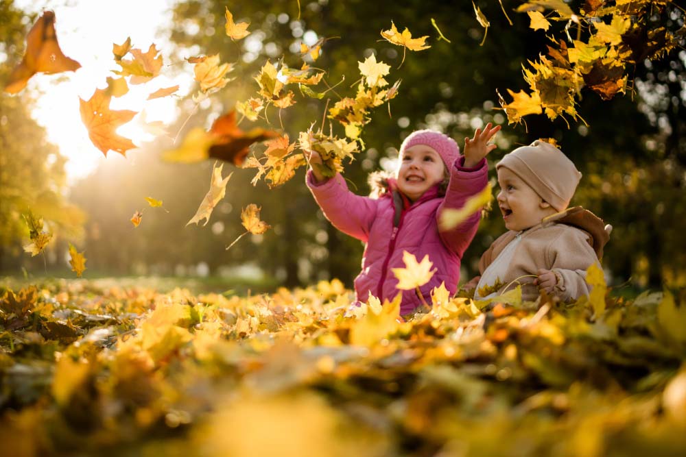 herbstfotografie kinder spielen mit blaettern