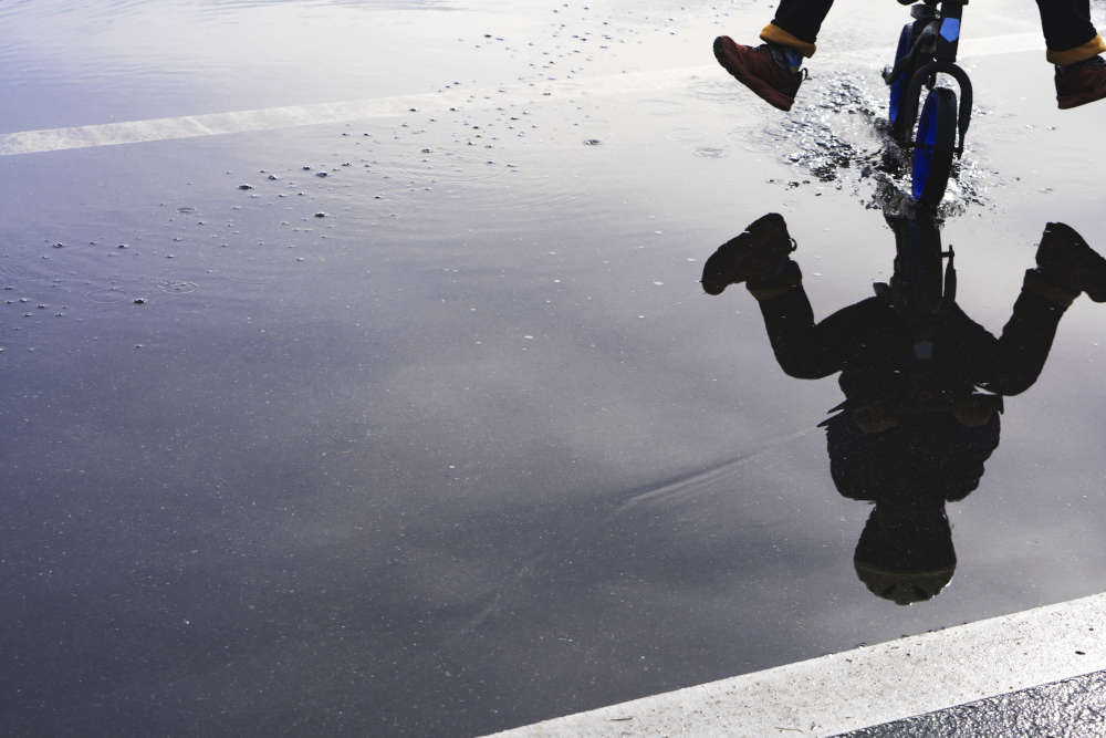 kid driving through puddle