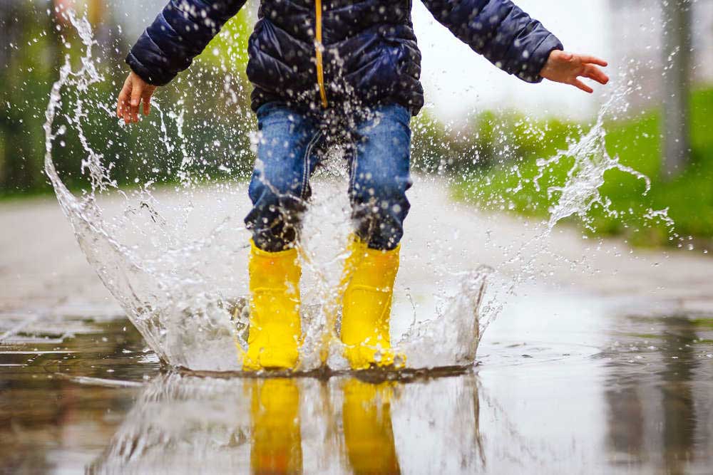 kid jumping into puddle
