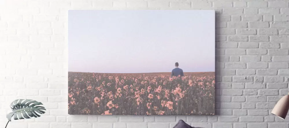 Was ist der Unterschied zwischen einem Poster und einer Leinwand. Leinwand an einer weißen Backsteinwand.