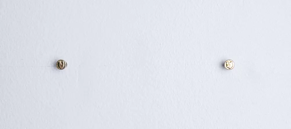 Zwei Nägel in Waage zueinander an der Wand