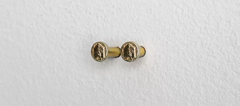 2 Nägel aus dem MEINFOTO Aufhängeset in Waage in der Wand