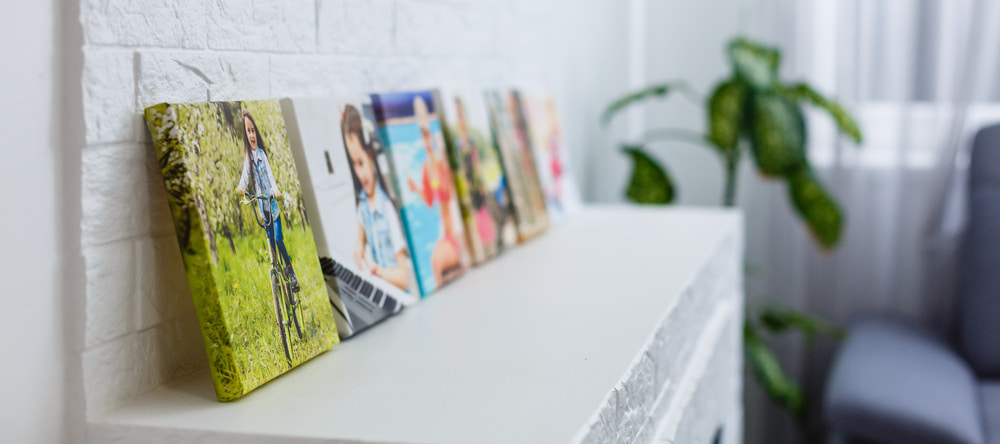 Where to Buy Canvas Prints in the UK. Row of photo canvas prints on shelf.