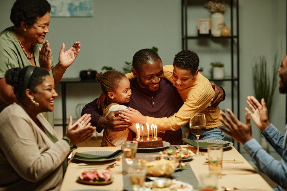 Family gathering around a birthday cake